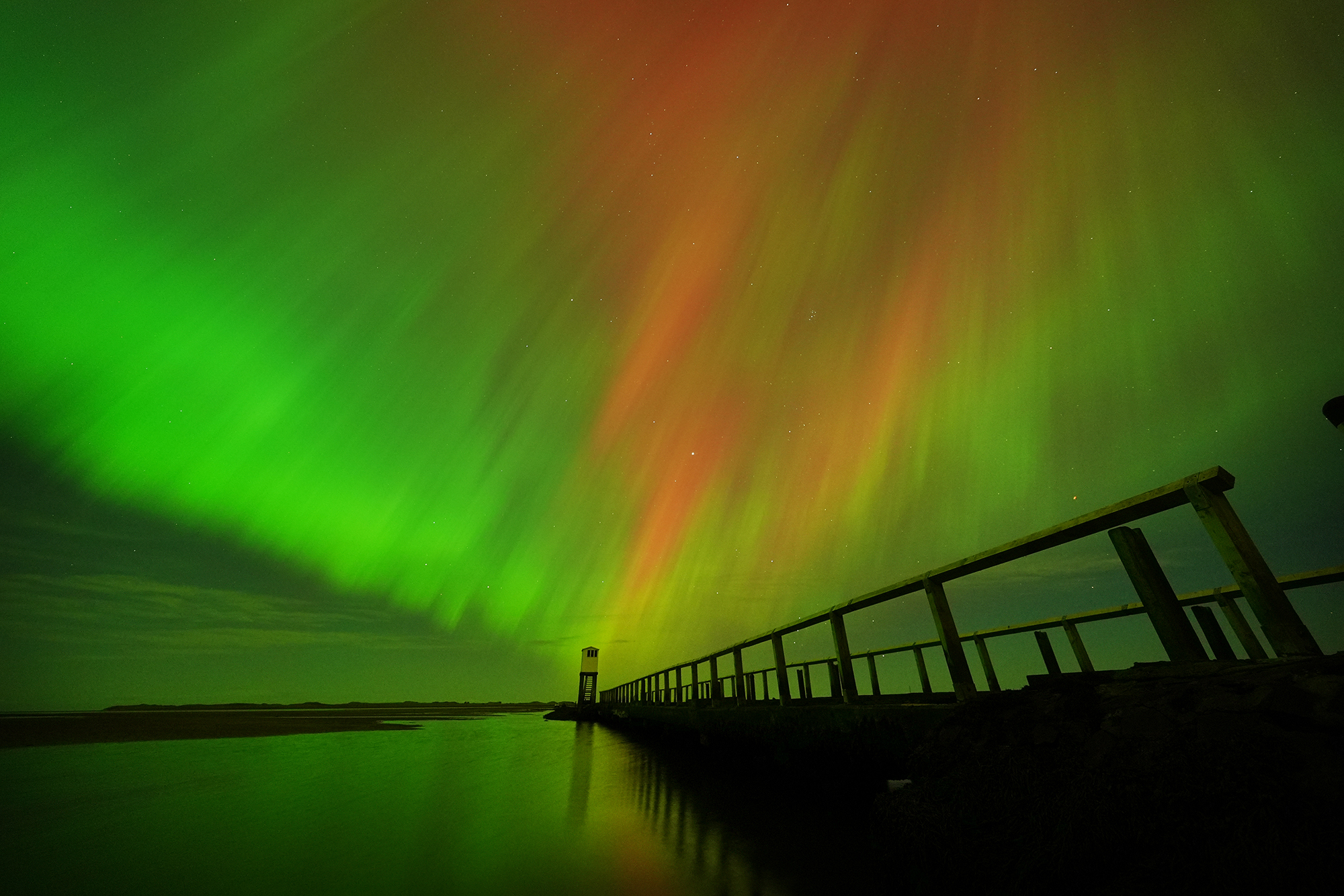 Το Βόρειο Σέλας, γνωστό και ως Aurora Borealis, φαίνεται σε μια απίστευτη εμφάνιση στον ουρανό πάνω από την καλύβα του καταφυγίου στο μονοπάτι που οδηγεί στο Holy Island στο Northumberland, στη βορειοανατολική ακτή της Αγγλίας, τις πρώτες πρωινές ώρες ή το πρωί της Παρασκευής. Οι οθόνες Aurora εμφανίζονται όταν φορτισμένα σωματίδια συγκρούονται με αέρια στην ατμόσφαιρα της Γης γύρω από τους μαγνητικούς πόλους. Καθώς συγκρούονται, το φως εκπέμπεται σε διάφορα μήκη κύματος, δημιουργώντας πολύχρωμες οθόνες στον ουρανό. Ημερομηνία φωτογραφίας: Παρασκευή 11 Οκτωβρίου 2024. (Φωτογραφία από τον Owen Humphreys/PA Images μέσω Getty Images)