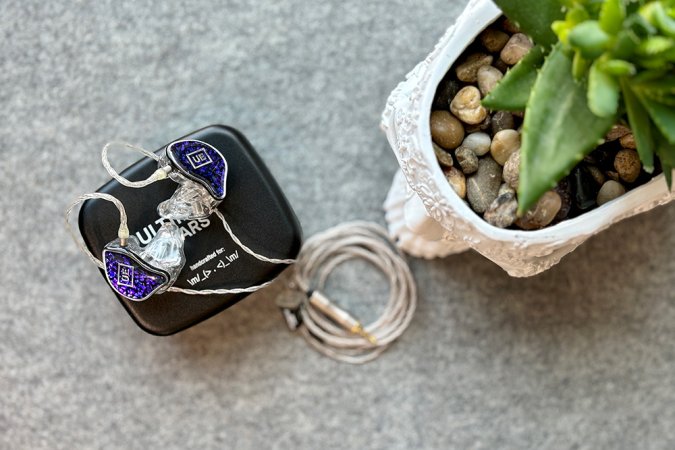  Amethyst and silver UE branded Premier custom molded in-ear monitors for performers on top of a black Ultimate Ears carrying case