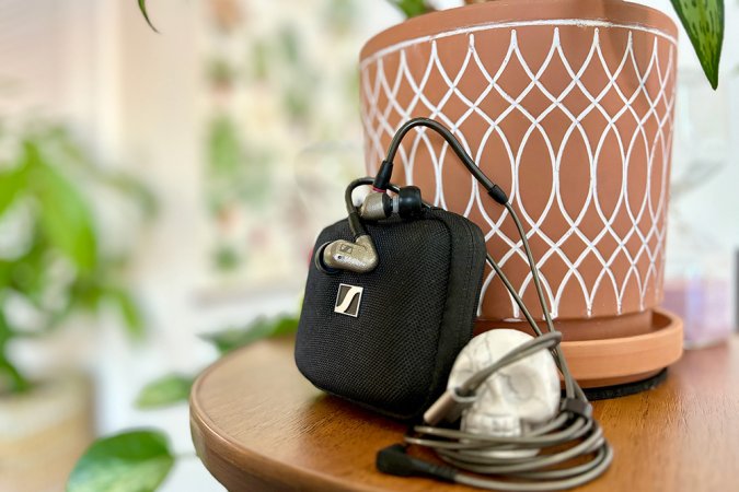  Textured silver alloy IE 600 dynamic driver in-ear monitors hanging across a Sennheiser branded black carrying case